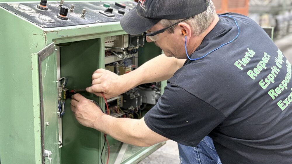 Électromécanicien effectuant un diagnostic électrique sur un équipement industriel.